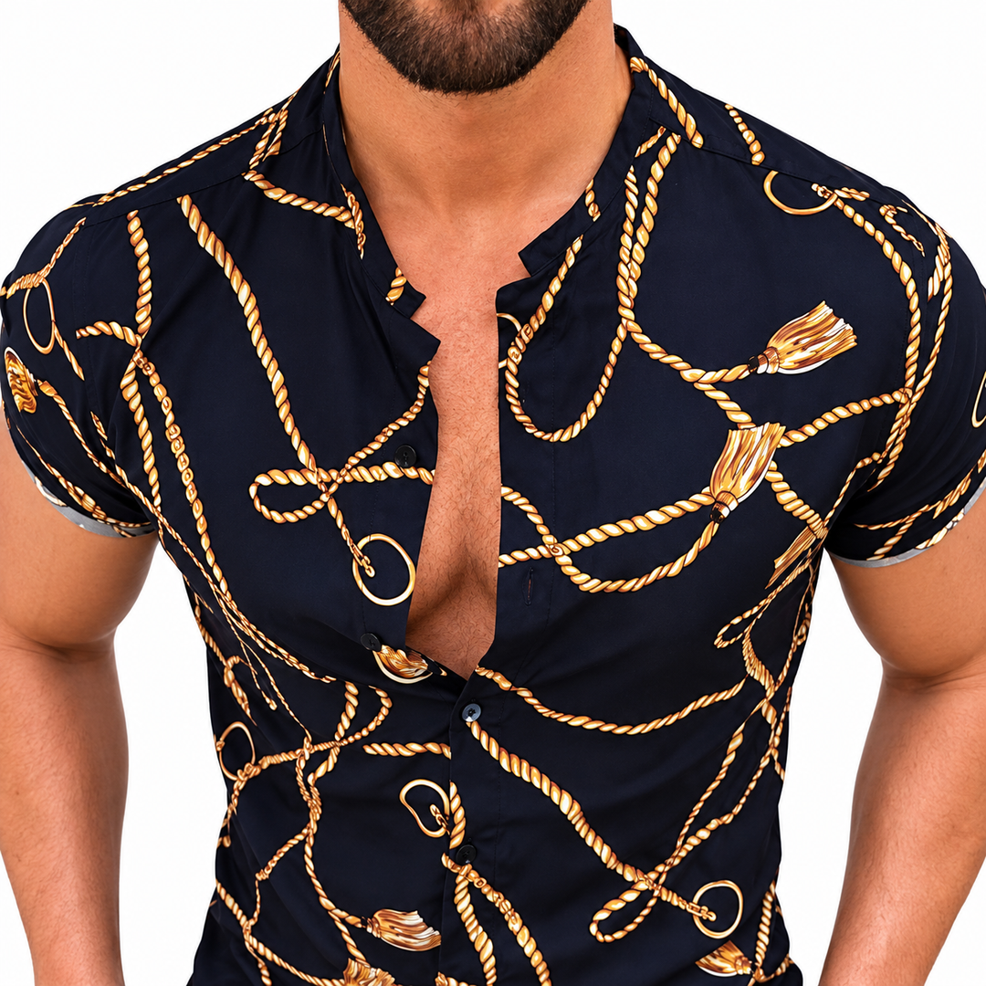 Close-up of the dark shirt front showing gold rope and chain motifs, short sleeve edges and an open collared button neckline.