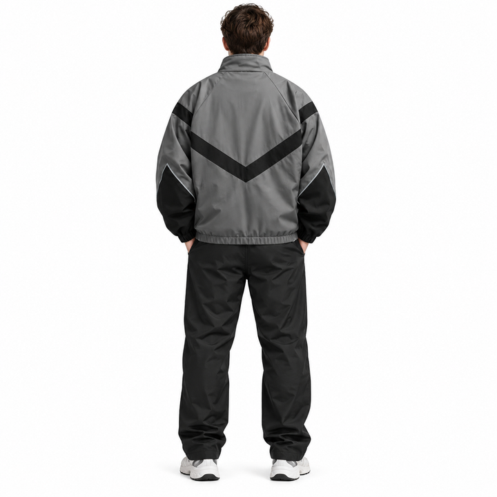 Back view of a male model wearing the gray with black style 6618 jacket with a V-shaped panel, gathered hem and long sleeves.