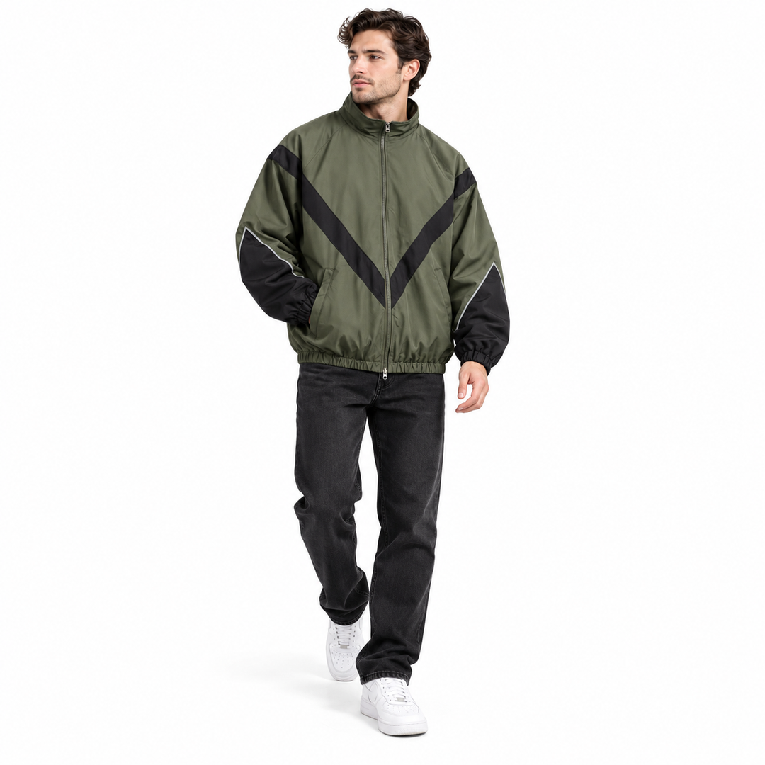 Male model walking in olive green with black style 6618 jacket with chevron contrast panels and stand collar, shown on white.