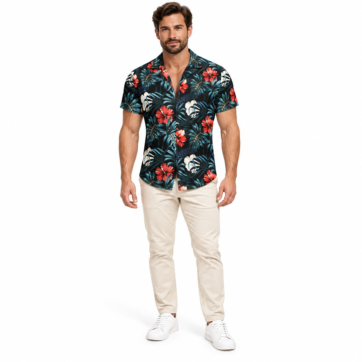 Adult model wearing the black multicolor tropical floral collared shirt with beige trousers and white sneakers against white.