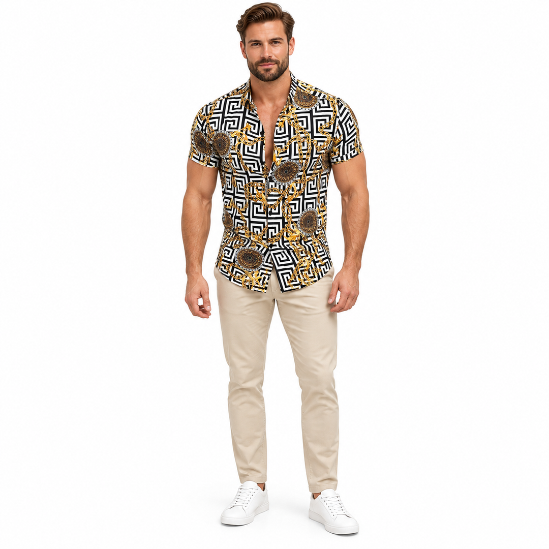 Male model wearing the black white and gold geometric short sleeve shirt in beige trousers and white shoes in a white studio.