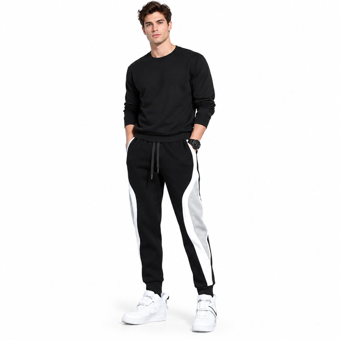 Men's sports pants in Black on a full-body male model, white background, showing drawstring waist and contrast side panels.