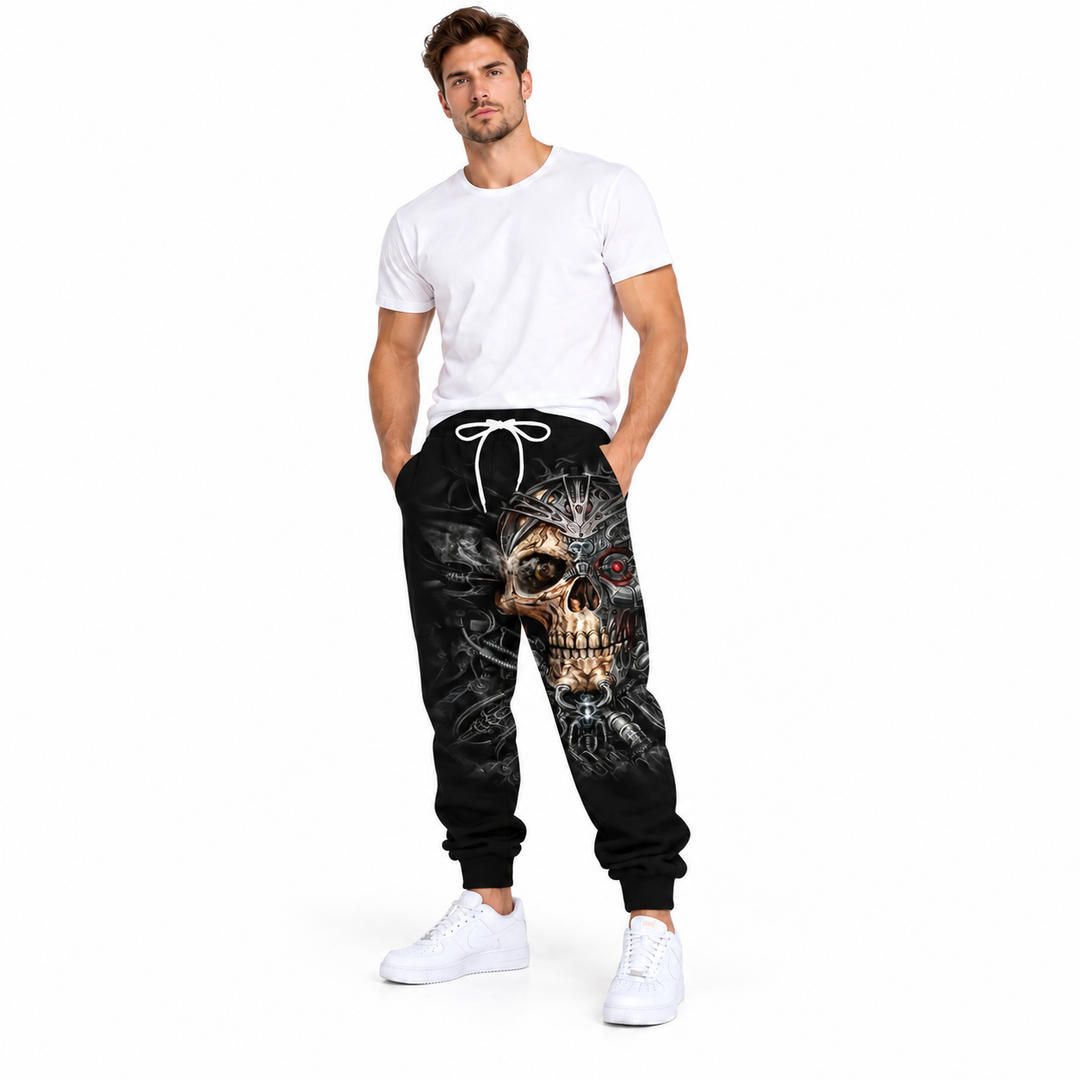 Male model wearing gold crown skull printed pants, with a plain white T-shirt and white sneakers, in a full-body studio view.