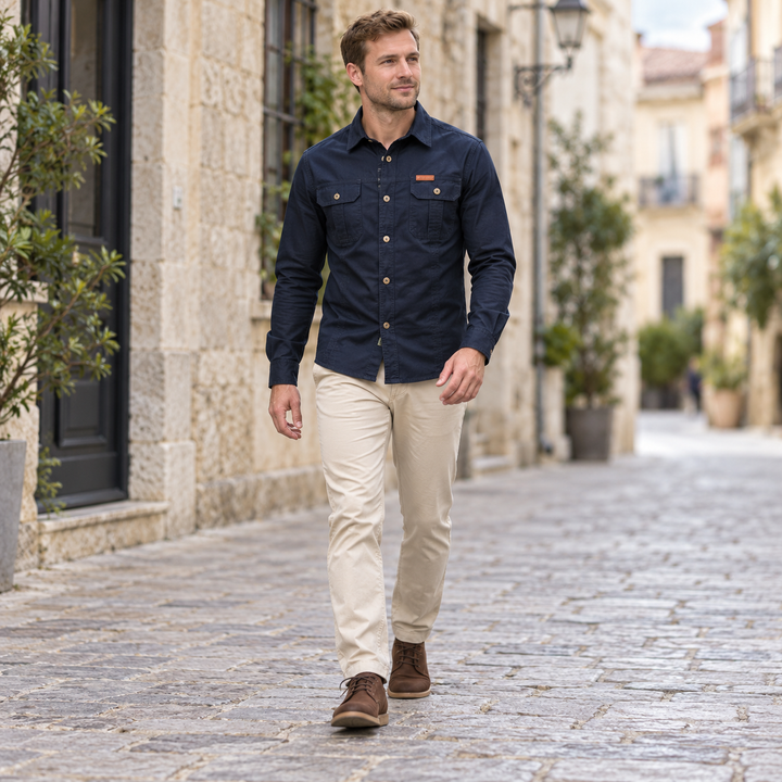 Full-body model walking in a navy blue utility shirt with buttoned chest pockets.