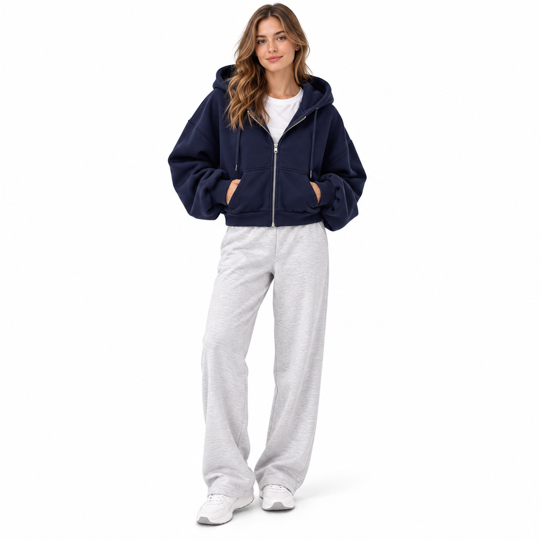 Photograph of navy cropped zip up hoodie in navy blue, front view, showing garment details, against a plain white background.