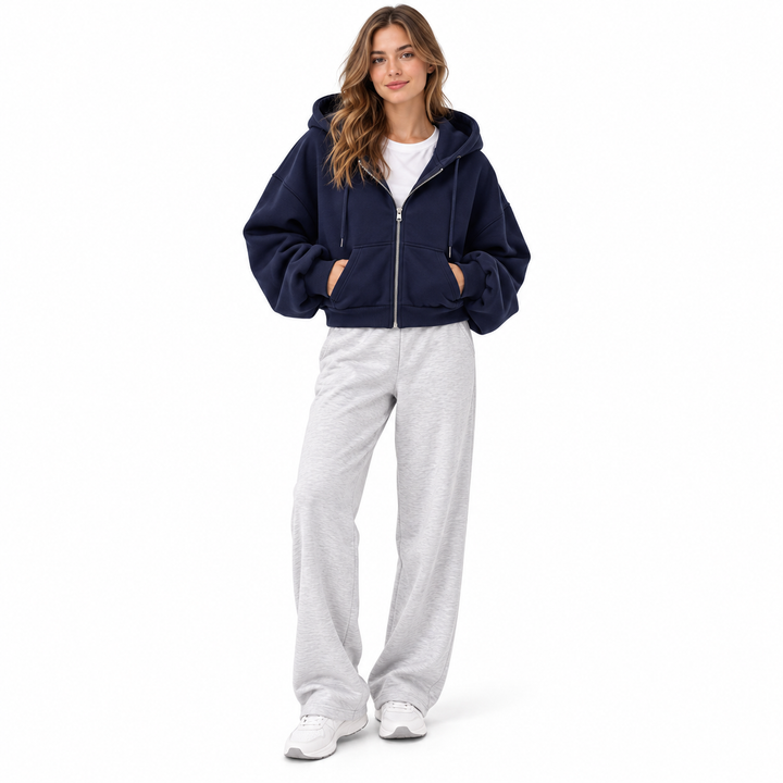 Photograph of navy cropped zip up hoodie in navy blue, front view, showing garment details, against a plain white background.