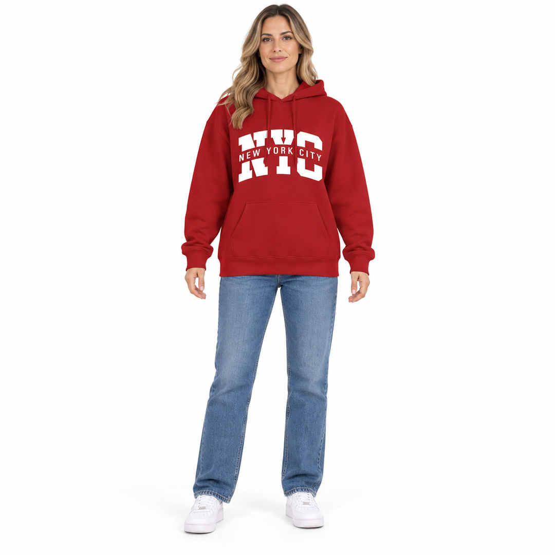 Full body model in a red hoodie with NYC City graphic print, blue jeans and white sneakers against a white studio background.