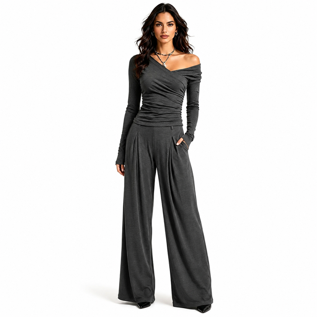 Women's off shoulder wide leg pants set in charcoal with ruched long sleeve top and flowing full length trousers on white.