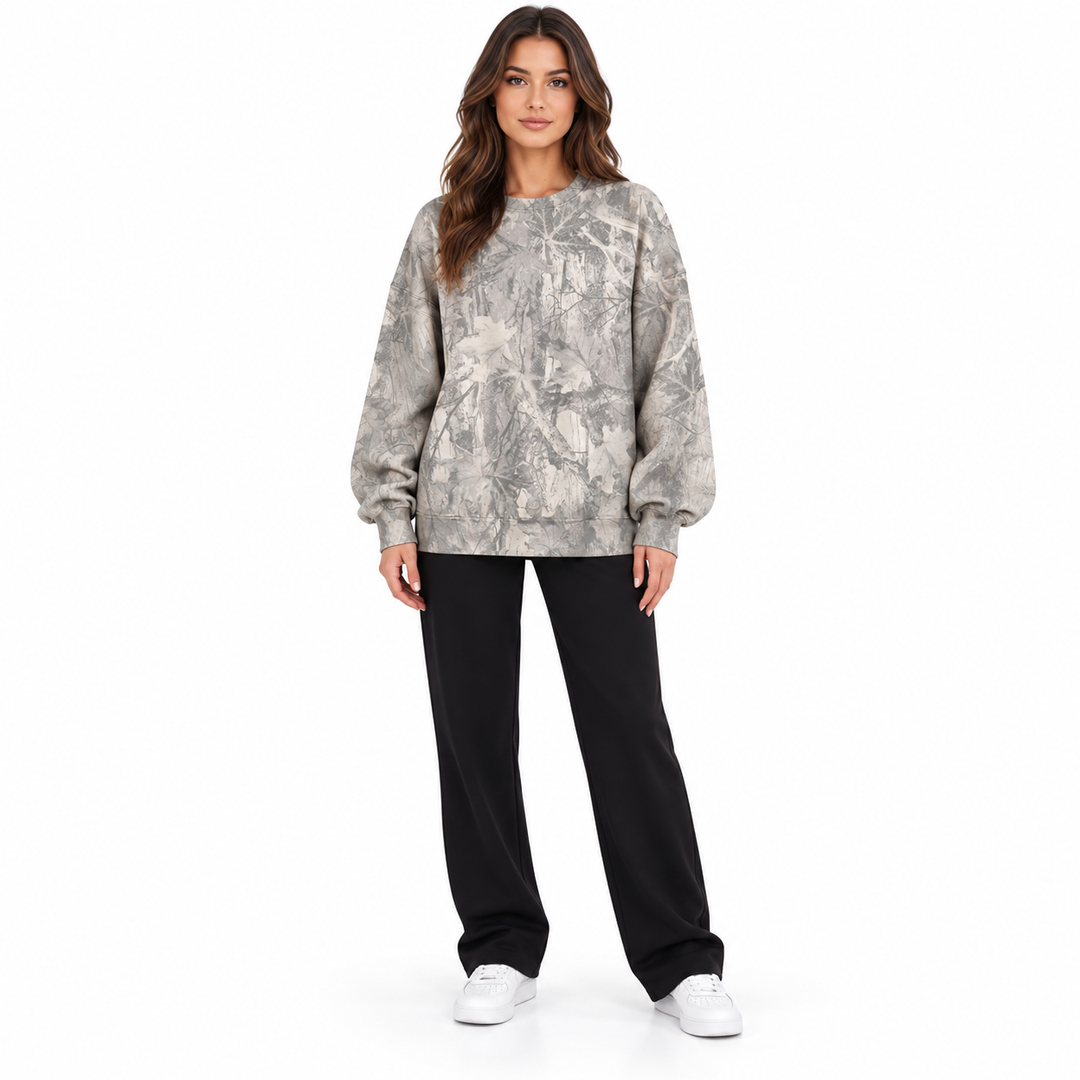 Model wearing a grey branch print sweatshirt shown standing from the front with sleeves visible on a seamless white backdrop.