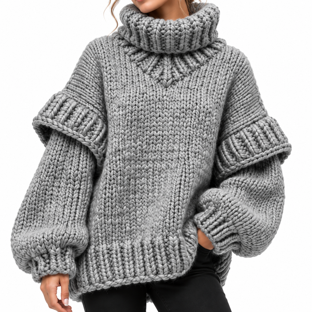 Gray knit sweater close-up showing sleeve volume, cuff and hem ribbing