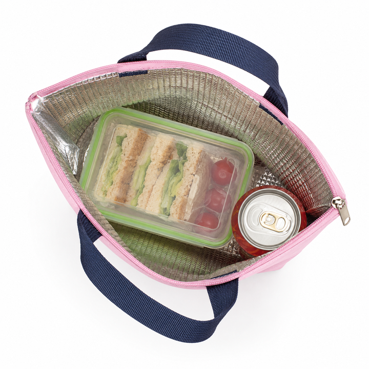Opened pink lunch tote with silver PEVA lining, meal container and drink can shown from above to highlight insulated storage.