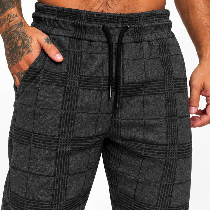 Dark grey plaid jogger pants macro detail with elastic waist, black drawstring, check pattern, side pocket and fabric texture