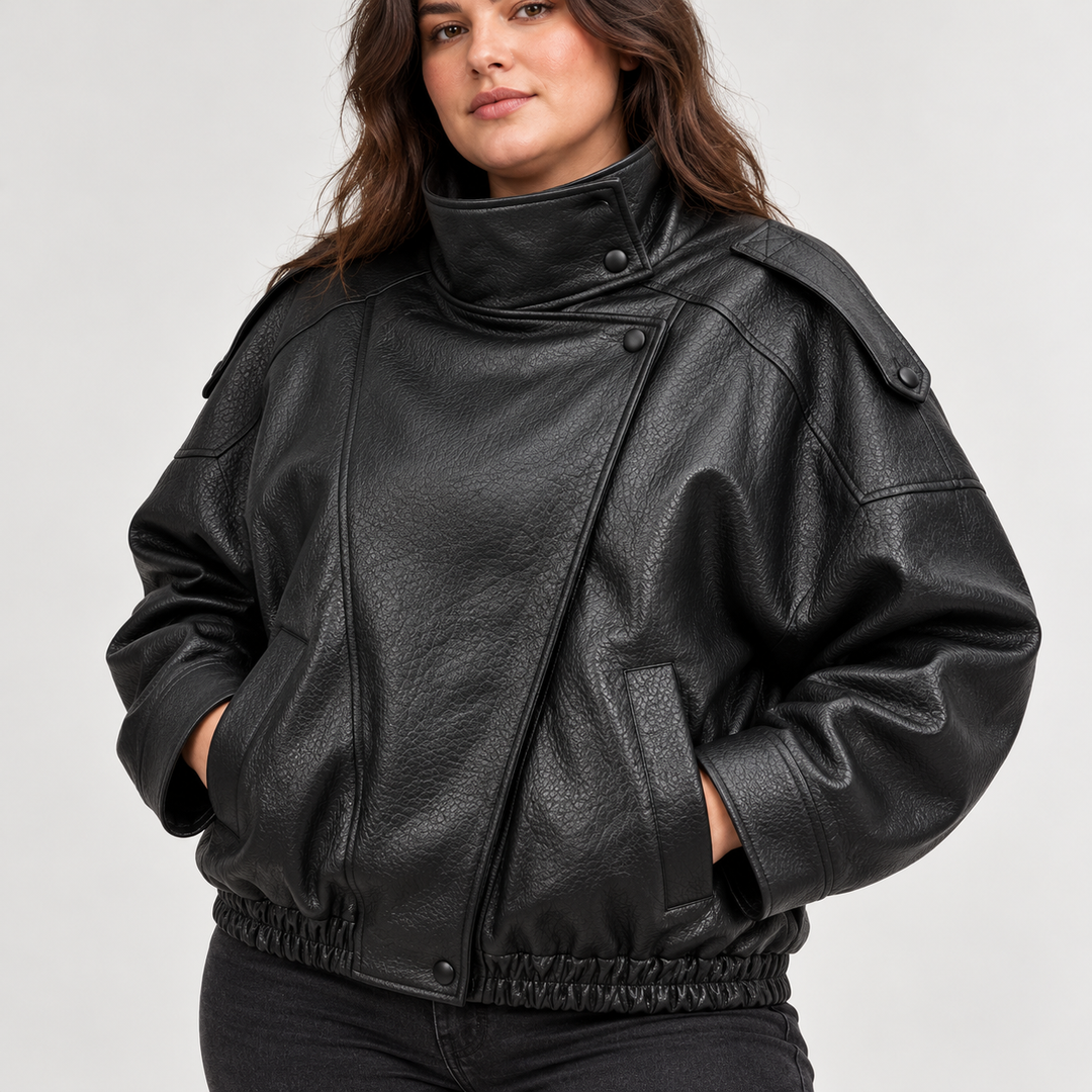 Detail of Black jacket front with textured leather-look finish, stand collar, pocket details, front zip and shoulder details.
