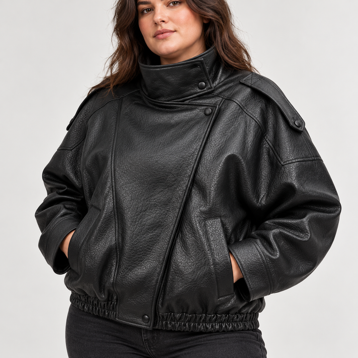 Detail of Black jacket front with textured leather-look finish, stand collar, pocket details, front zip and shoulder details.