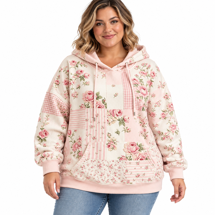 Plus size floral hoodie in blush pink with drawstrings and a kangaroo pocket, shown on a model against white