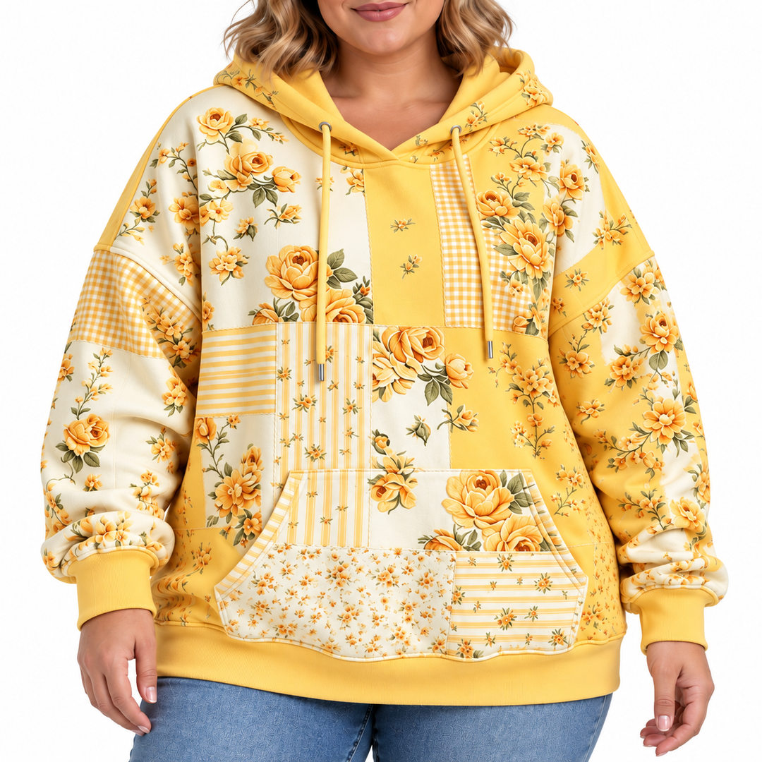 Plus size floral hoodie in yellow, close-up showing floral patchwork print, drawstrings, pocket and ribbed cuffs