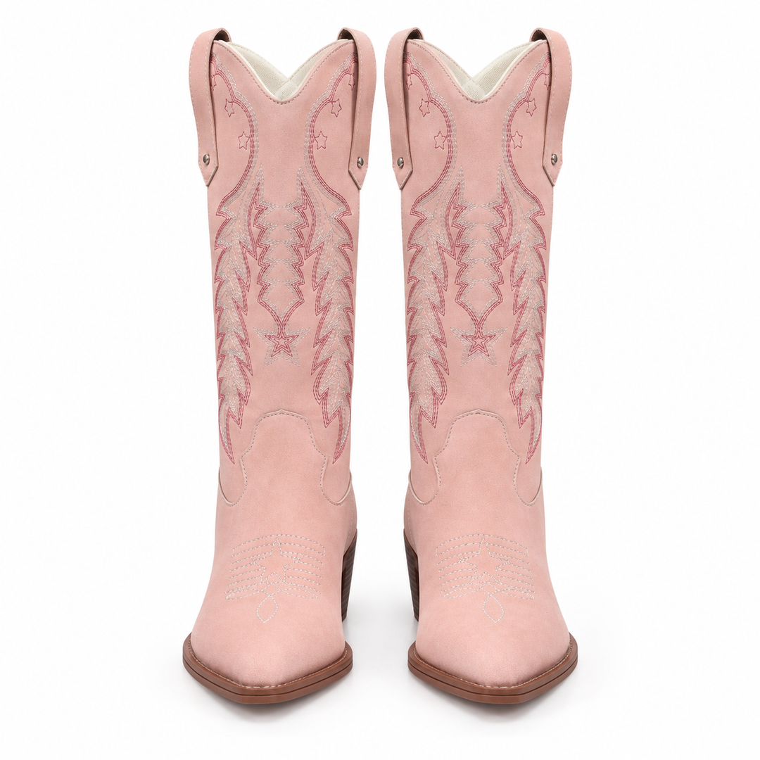 Front view of pink western boots with embroidered shafts, pointed toes and brown heels on a seamless white studio background.
