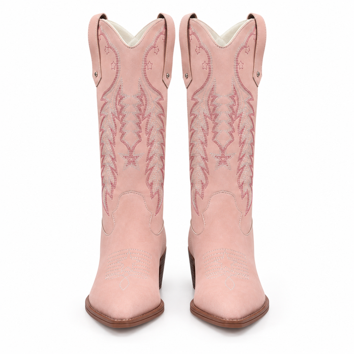 Front view of pink western boots with embroidered shafts, pointed toes and brown heels on a seamless white studio background.
