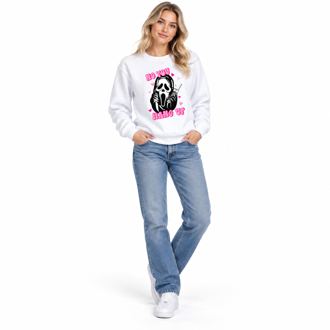 Woman wearing a white graphic pullover with pink lettering, a black phone graphic and ribbed cuffs in a white studio setting.