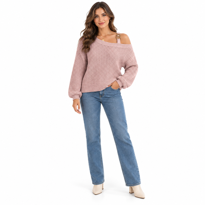 Pink knit sweater with a metal buckle shoulder strap and lantern sleeves on a brunette woman wearing blue jeans in the studio
