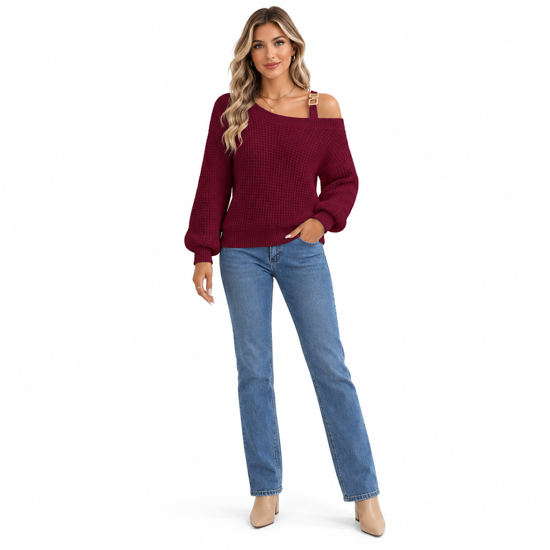 Wine red knit sweater with a gold-tone shoulder buckle and long lantern sleeves, styled with blue jeans on a white background