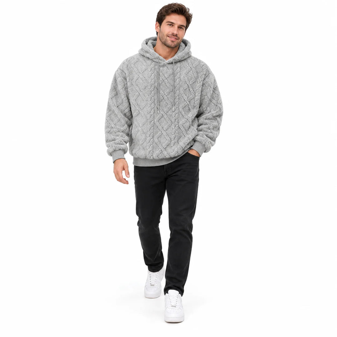 Light grey textured pullover shown on a walking male model in a white studio, with matching hood ties, black jeans and shoes.