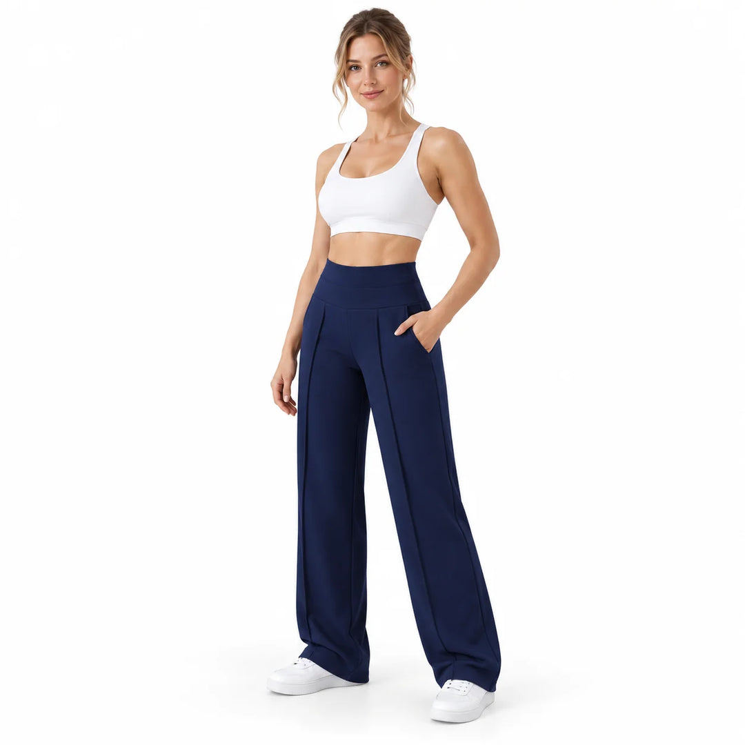 Navy blue trousers on a full-body model in a white studio, with a high waistband, front pleats and the curved pocket opening.