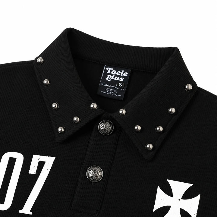 Close-up of the black polo collar with silver studs, two engraved silver buttons, inner label and partial white chest prints.