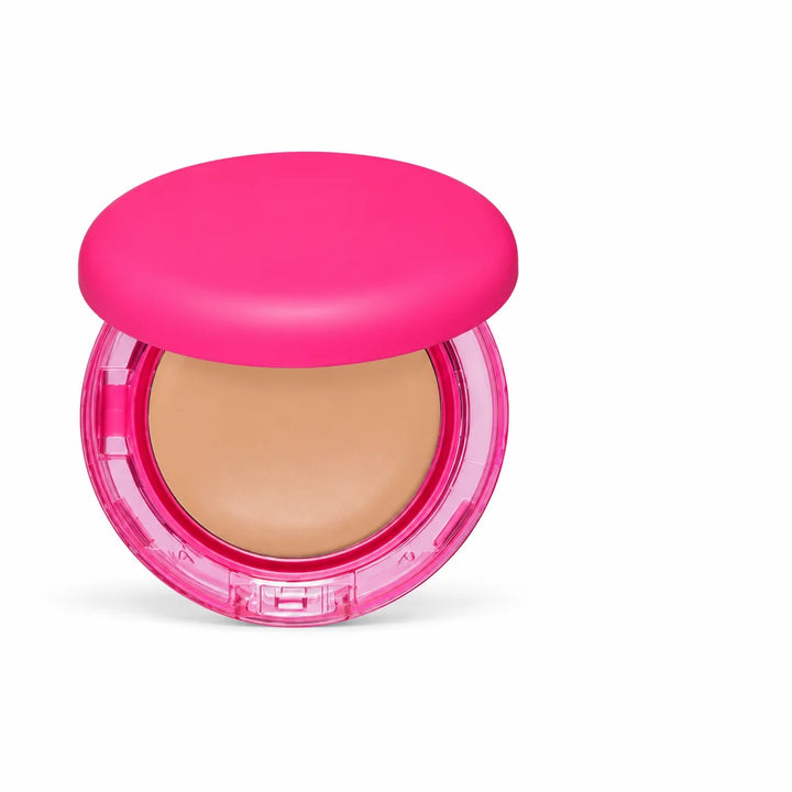 Pink foundation compact viewed from the front, positioned left of center with a beige pan and clear front clasp fully visible