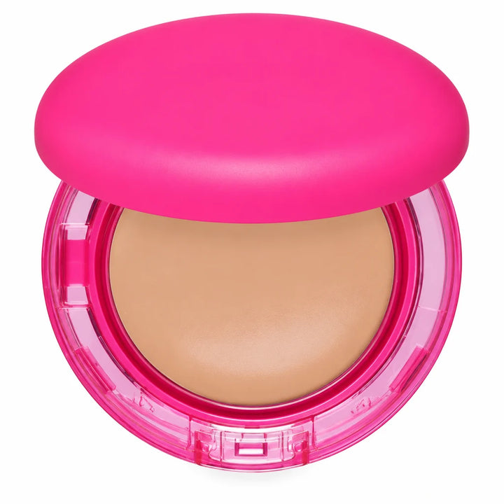 Close view of the beige foundation pan inside a pink compact, with the transparent lower rim and front clasp shown in detail.