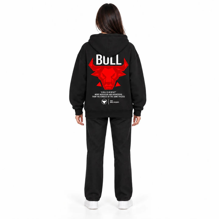 Unisex graphic hoodie in black with a red bull back print, shown on a full-body female model against a white studio backdrop.