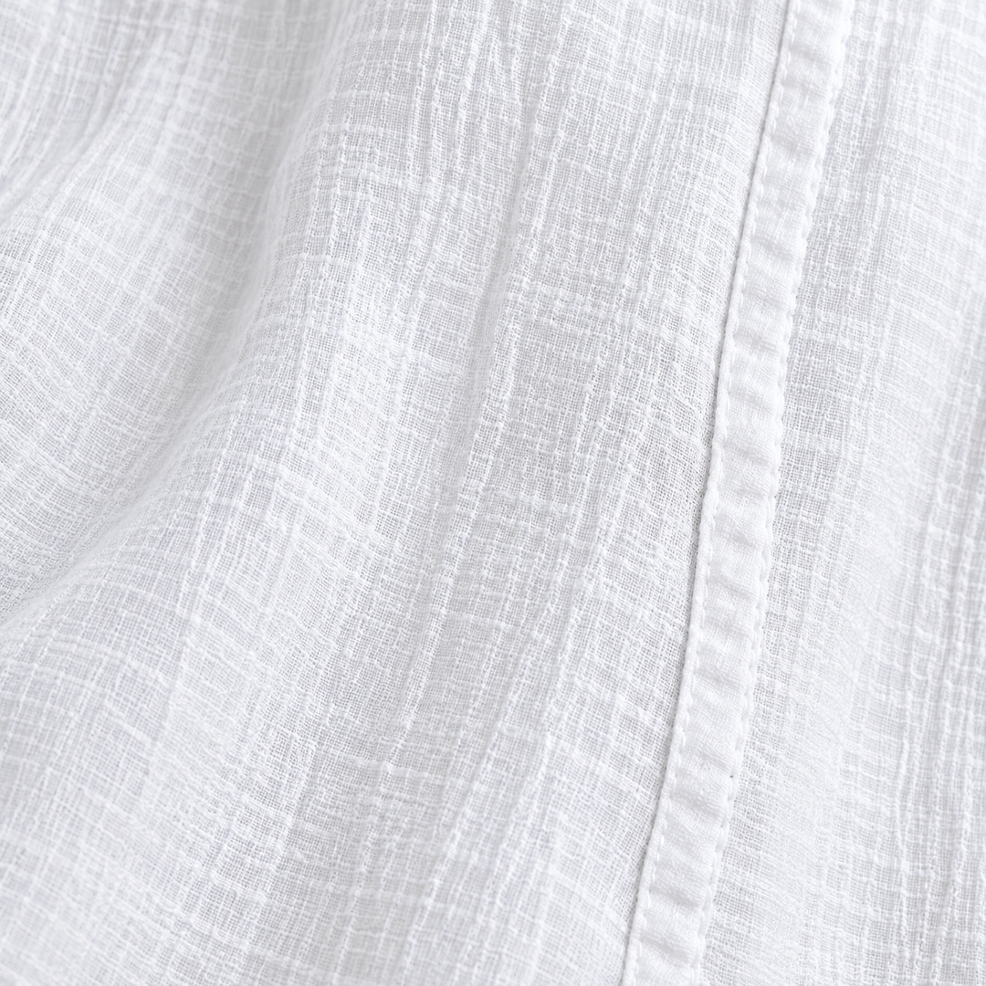 Close-up of the White trousers crinkle fabric texture and nearby leg seam
