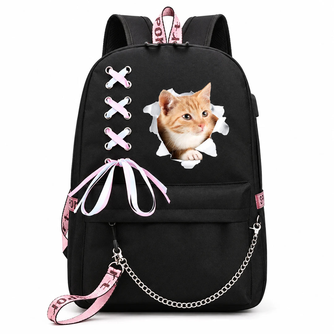 Kawaii cat backpack in black with an orange kitten design, pink-and-white ribbon bow and silver chain, photographed on white.