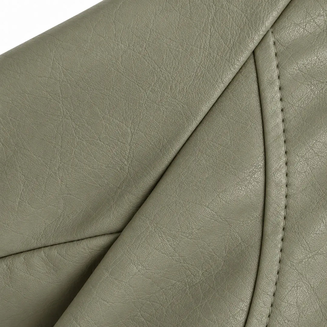 Gray Green faux leather grain shown in a close-up with the curved stitched panel seam and textured surface in a white studio.