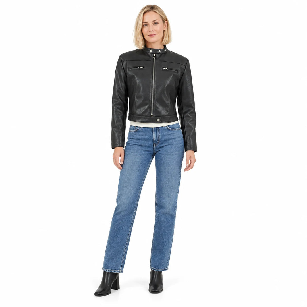 Black jacket on a blonde model in a full-length front view, with blue straight jeans and black ankle boots in a white studio.
