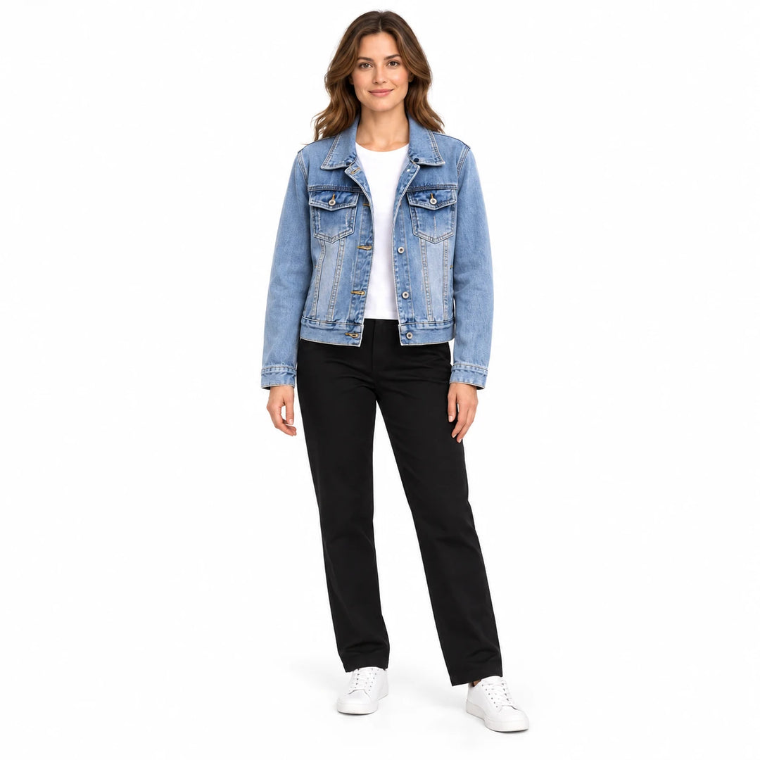 Women's cropped denim jacket in light blue with a collar, on a full-length model in black pants on a white studio background.