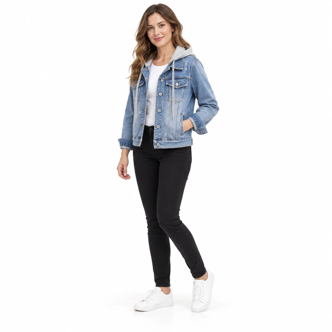 Angled front view of a woman in a light blue hooded denim jacket, white T-shirt and black pants on a white studio background.