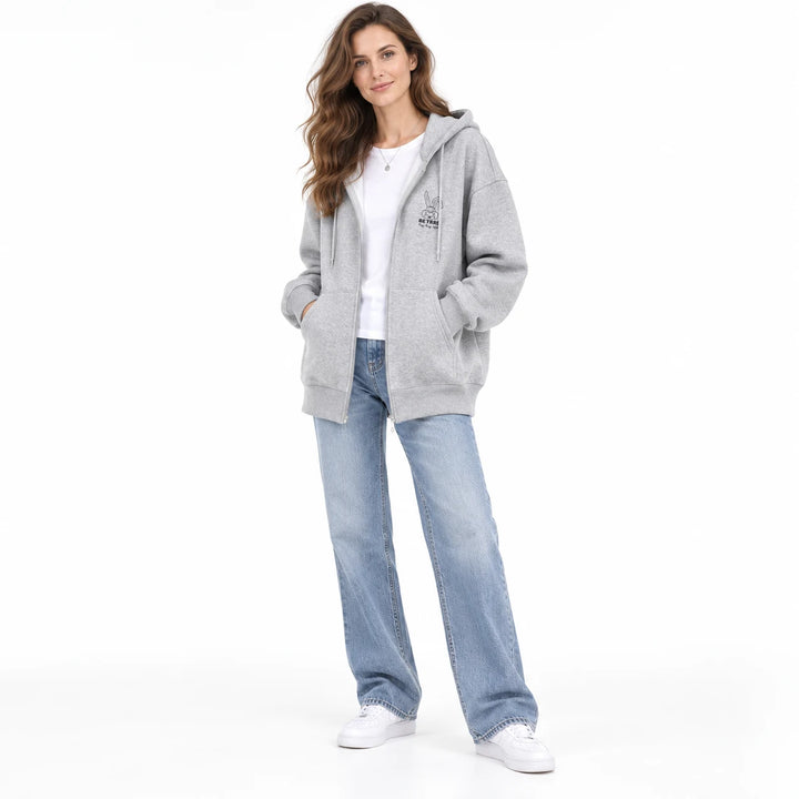 Gray rabbit motif zip hoodie worn by an adult woman, showing the hood, zipper and front pockets, on a plain white background.