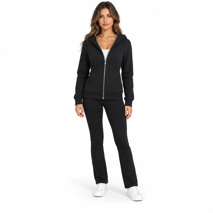 Full-body model wearing the Black zip hoodie, showing front pockets, ribbed cuffs and hem, against a white studio background.