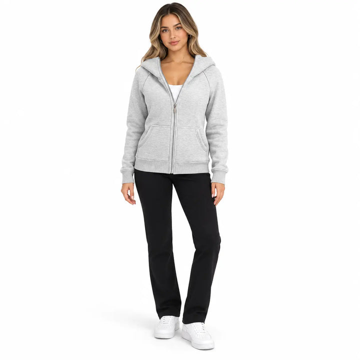 Full-body model wearing the Heather Gray zip hoodie, showing front pockets, ribbed cuffs and hem, with soft shadows on white.