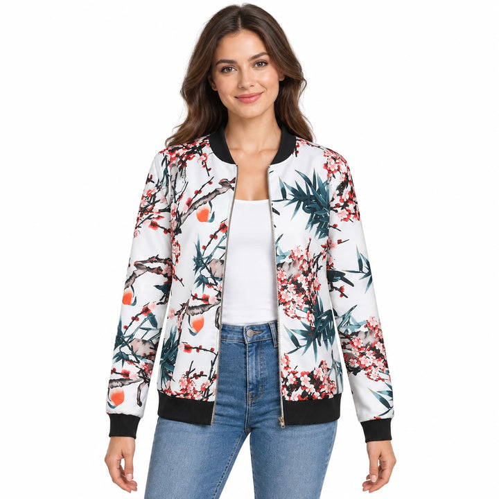 Model wearing a botanical print jacket with black ribbed trim over a white top and blue jeans against a plain white backdrop.