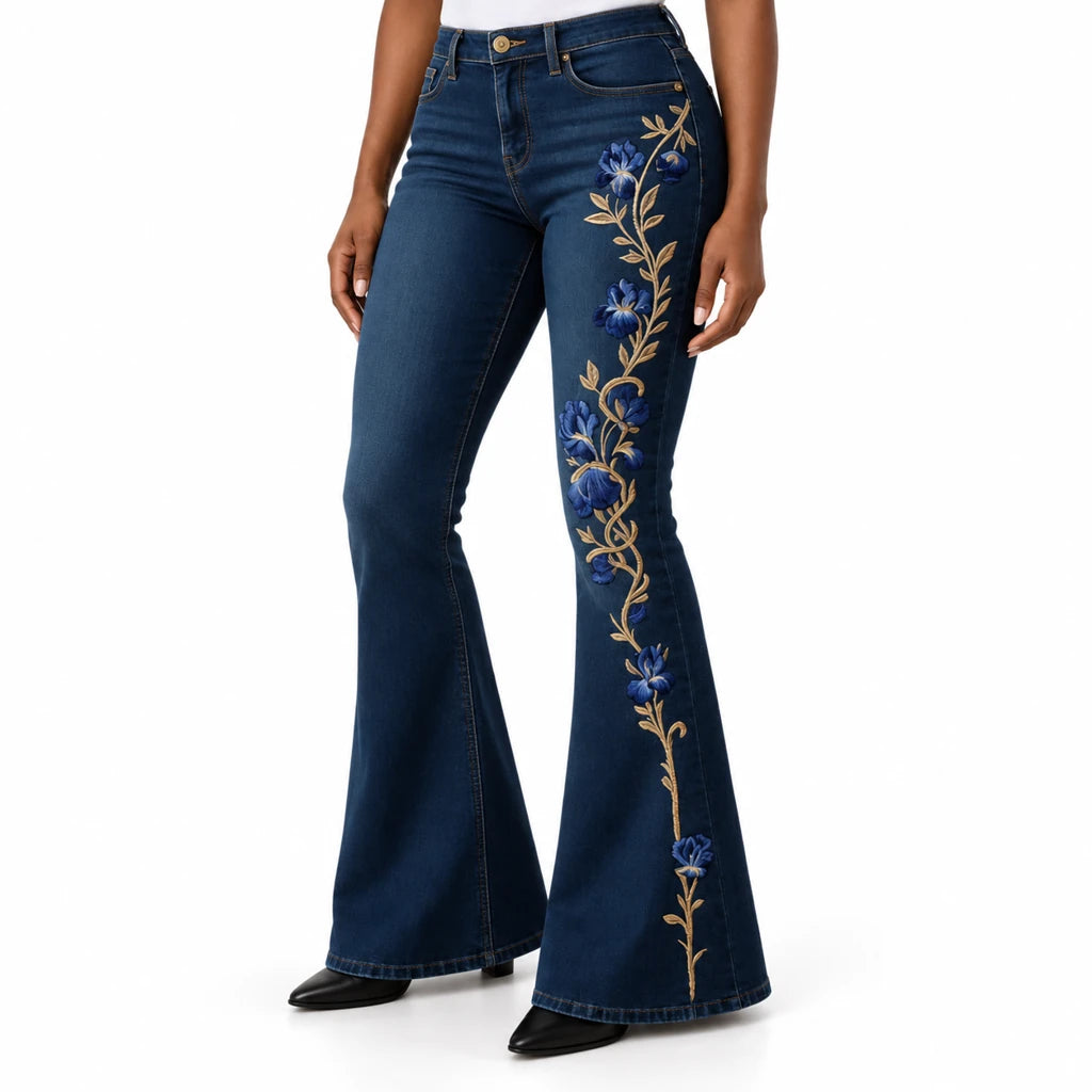 Close view of dark blue floral flare jeans showing the waist, slim upper leg, blue flower print and flared hem.