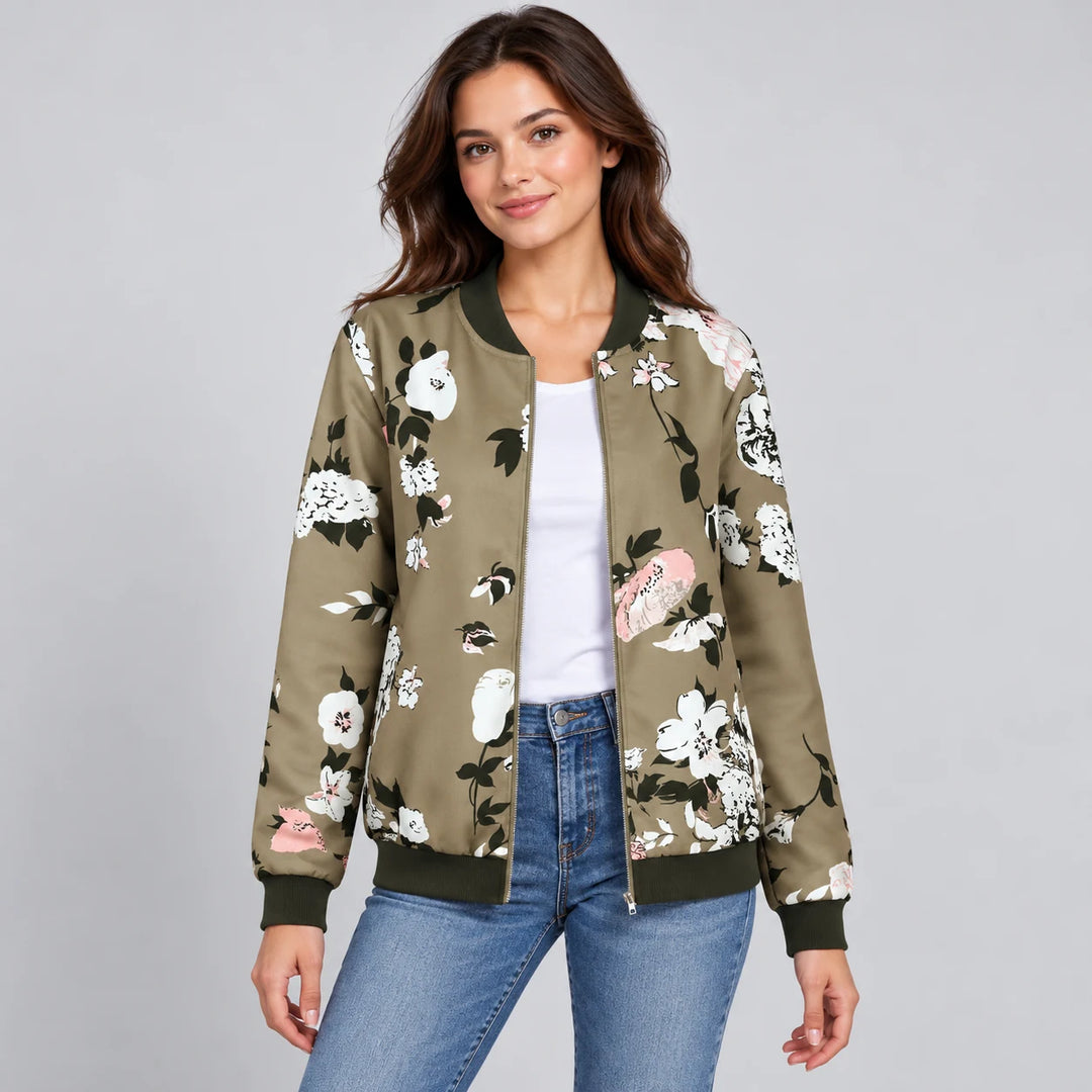Studio model wearing the Army Green printed zip-up jacket with blue jeans, showing white flowers, pink accents and dark trim.