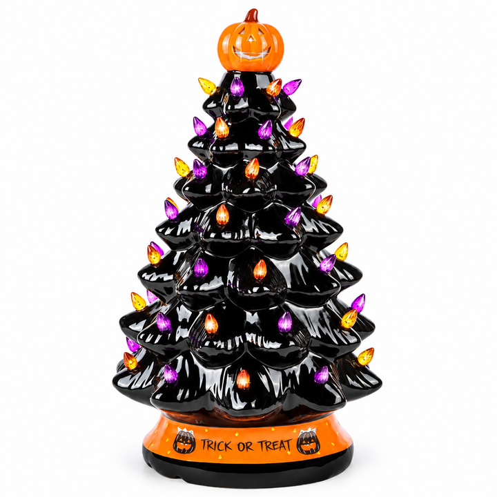 Near-front view of the black Halloween tree, showing its tiered shape, orange pumpkin topper and lettered base on pure white.