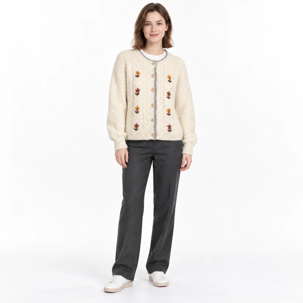 Embroidered cardigan view on a full-length model, with long sleeves, gray edging and floral details against a white backdrop.
