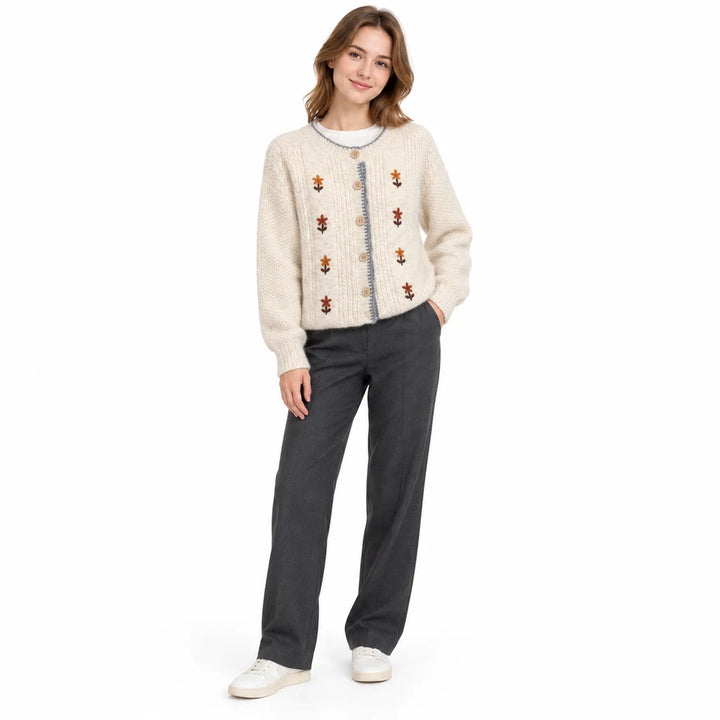 Ivory floral knit cardigan on a full-length model in a gentle front pose, showing long sleeves, gray trim and button placket.