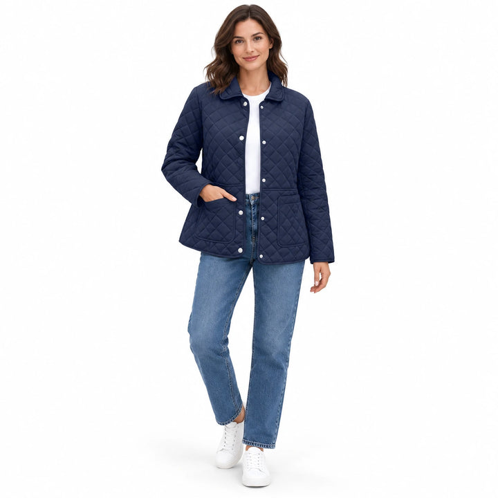 Navy Blue quilted jacket on a full-body model with blue jeans and white sneakers, in a casual pose in a white studio setting.