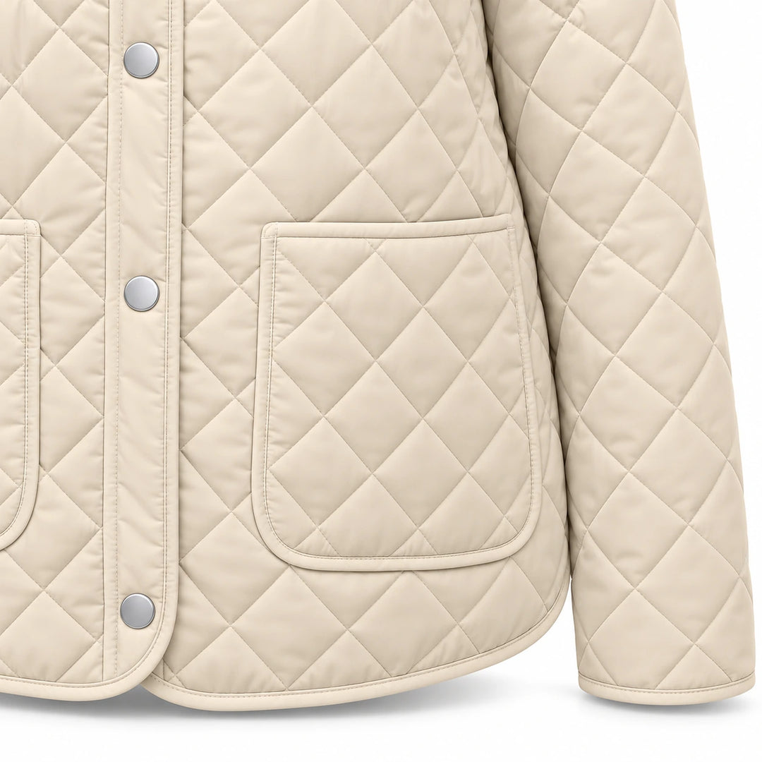 Front close-up of the Apricot jacket showing diamond quilting, one silver snap, the rounded patch pocket and bound front hem.