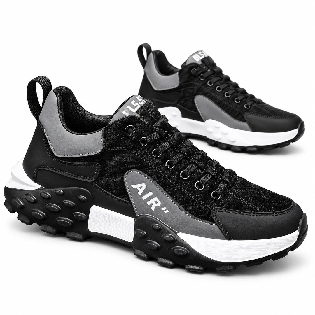 Black and Gray lace-up sneakers shown as a pair with contrasting white midsole sections and black sculpted soles in a studio.