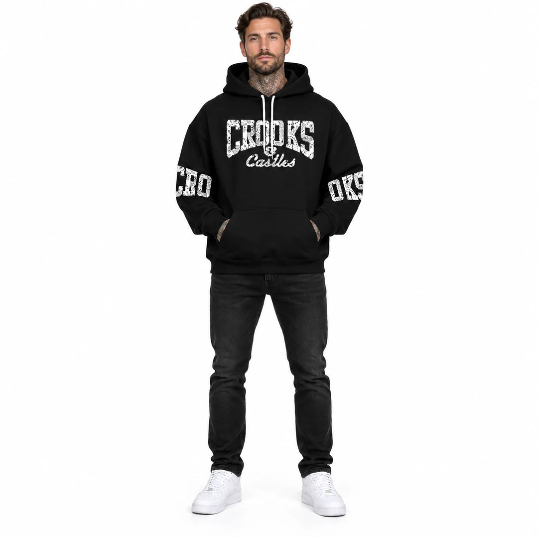 Full-length male model wearing a Black graphic hoodie with chest and sleeve prints on a white studio background